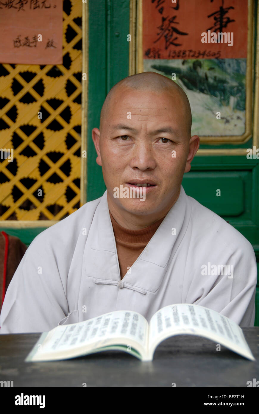 Chinese Buddhism, portrait, monk in a white dress reading a book, Gantong Temple in Dali, Yunnan Province, People's Republic of Stock Photo