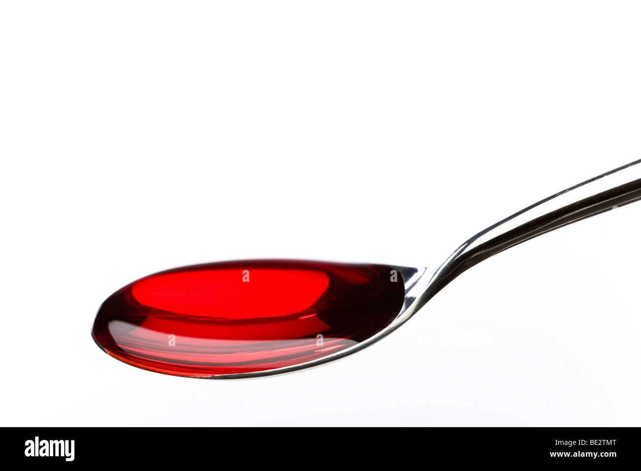 Spoon filled with red medicine Stock Photo
