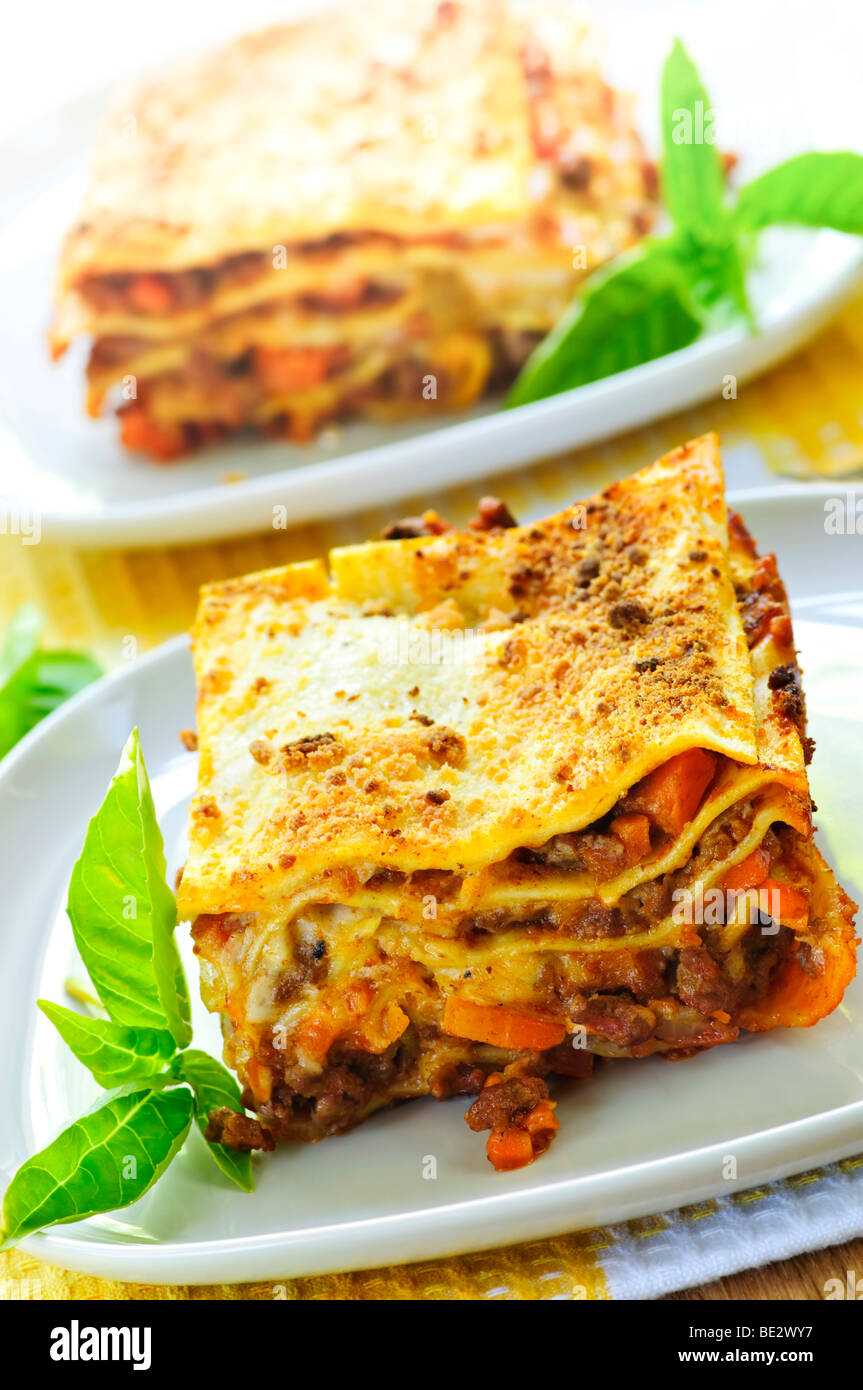 Two servings of fresh baked lasagna on plates Stock Photo