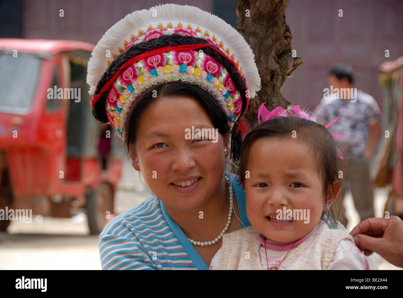Portrait, ethnology, woman of the Bai ethnic group with typical head-dress and a toddler, Yongning, Lugu Hu Lake area, Yunnan P Stock Photo