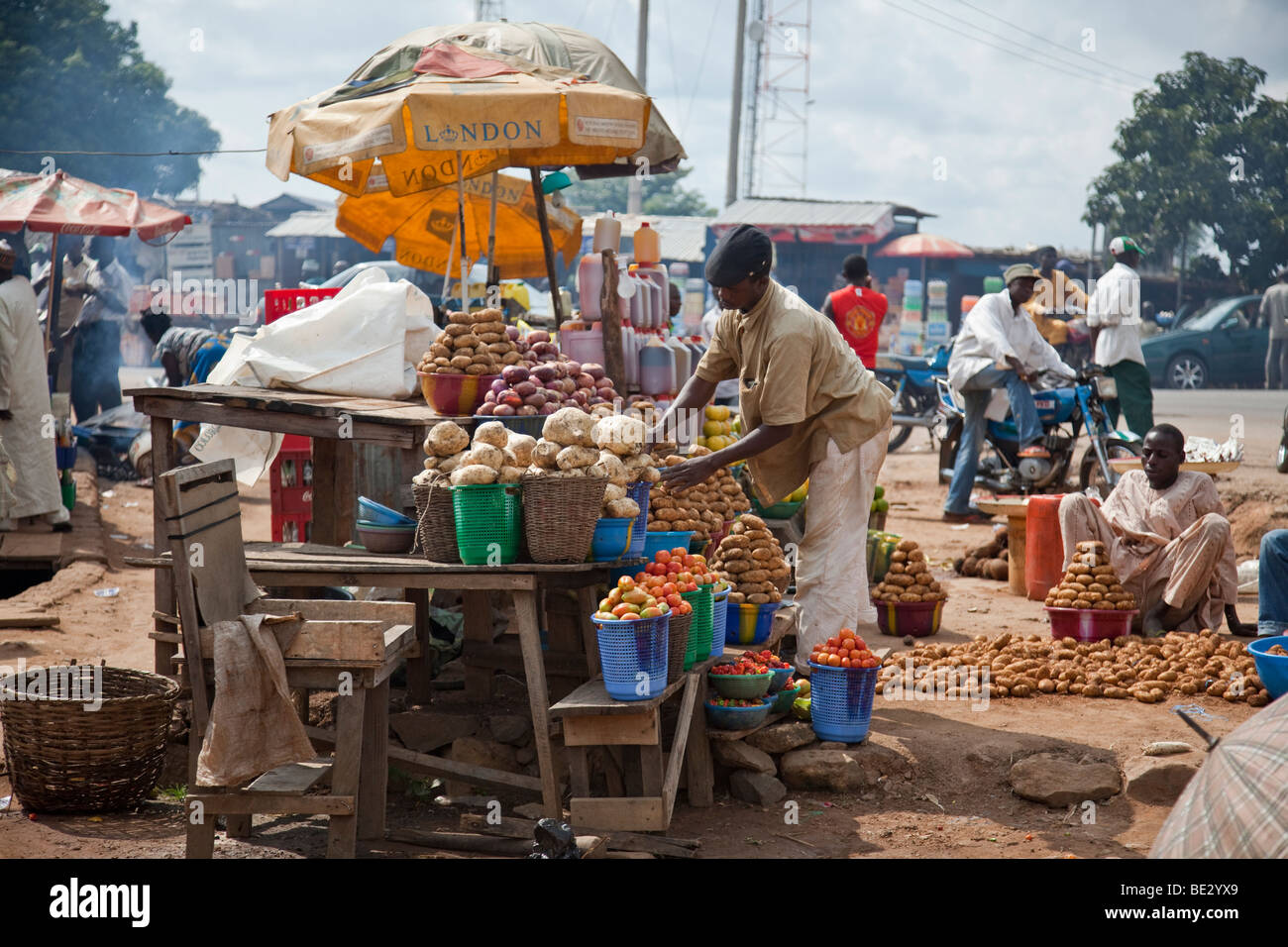 A boy mans a fruit and vegetable table at a roadside market in Nigeria's Niger State. Stock Photo