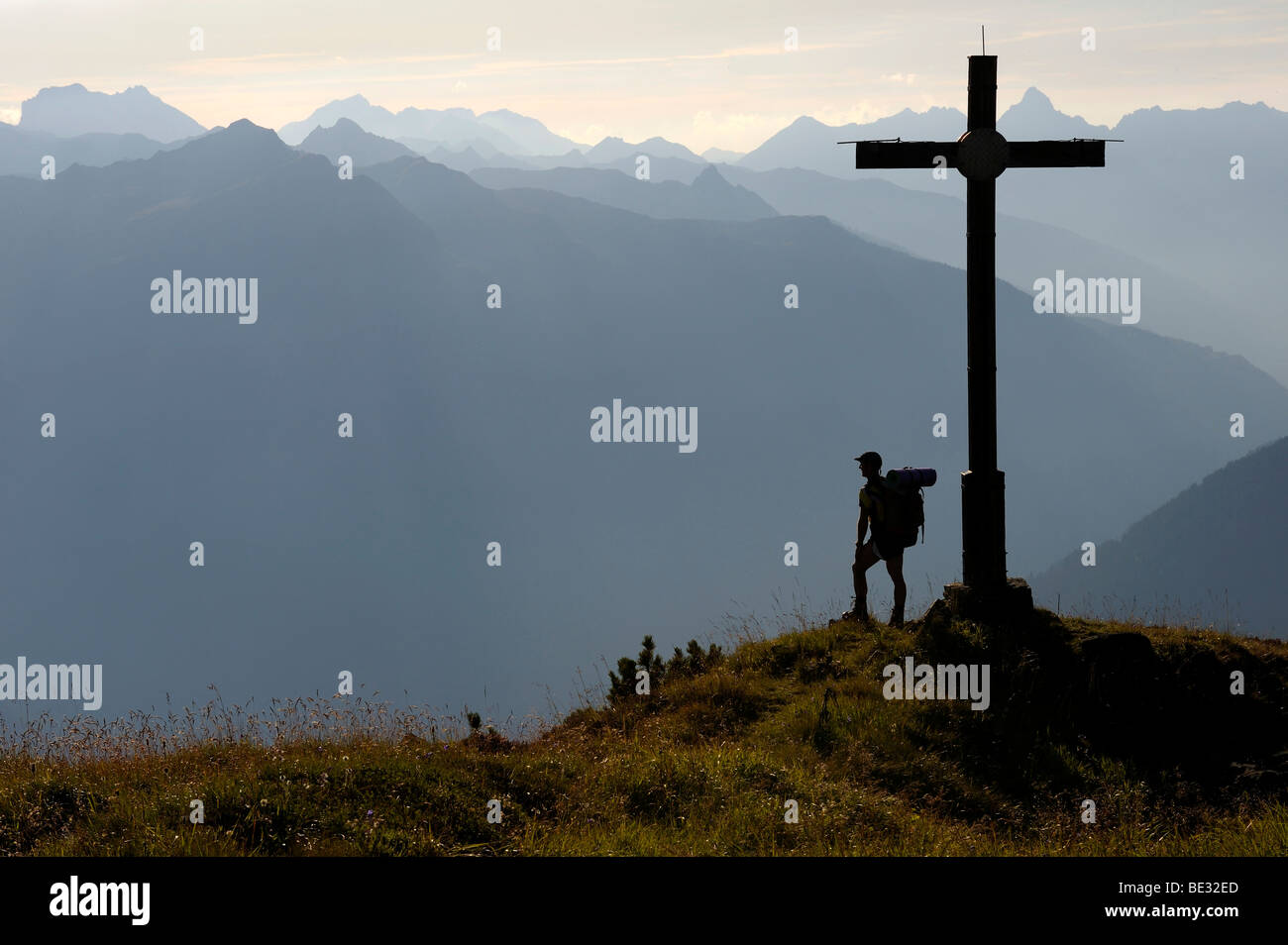 Mountain climber standing beside a summit cross, Gaschurn, Montafon, Vorarlberg, Austria, Europe Stock Photo