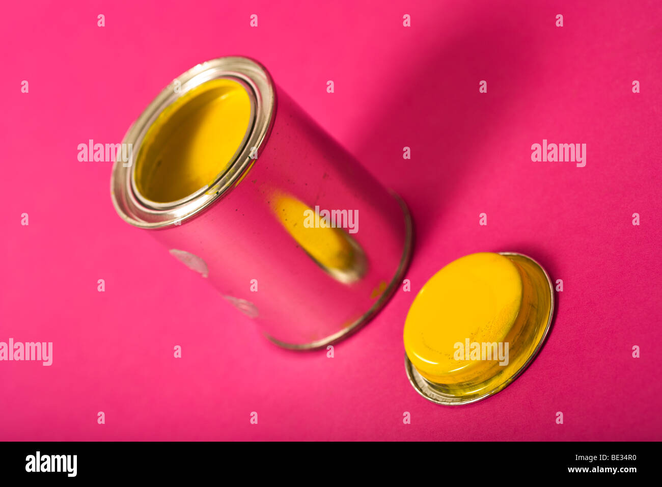 can of yellow paint on pink background Stock Photo
