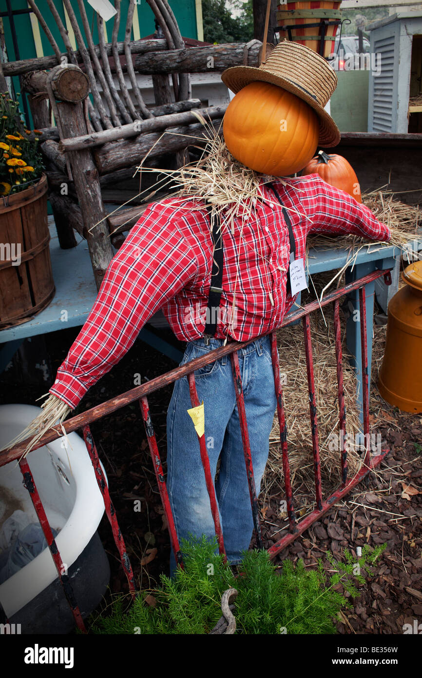 A pumpkin-headed scarecrow in the yard of an antique shop. Stock Photo
