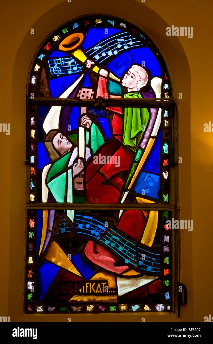 stained window with music scores and angels singing magnificat Stock Photo
