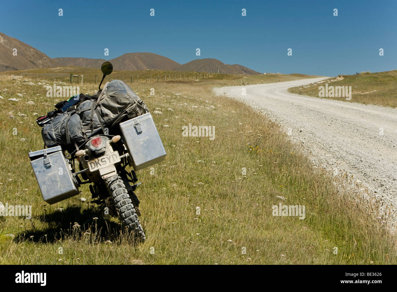 Enduro motorcycle standing next to a dusty dirt road, Hakatere, South Island, New Zealand Stock Photo