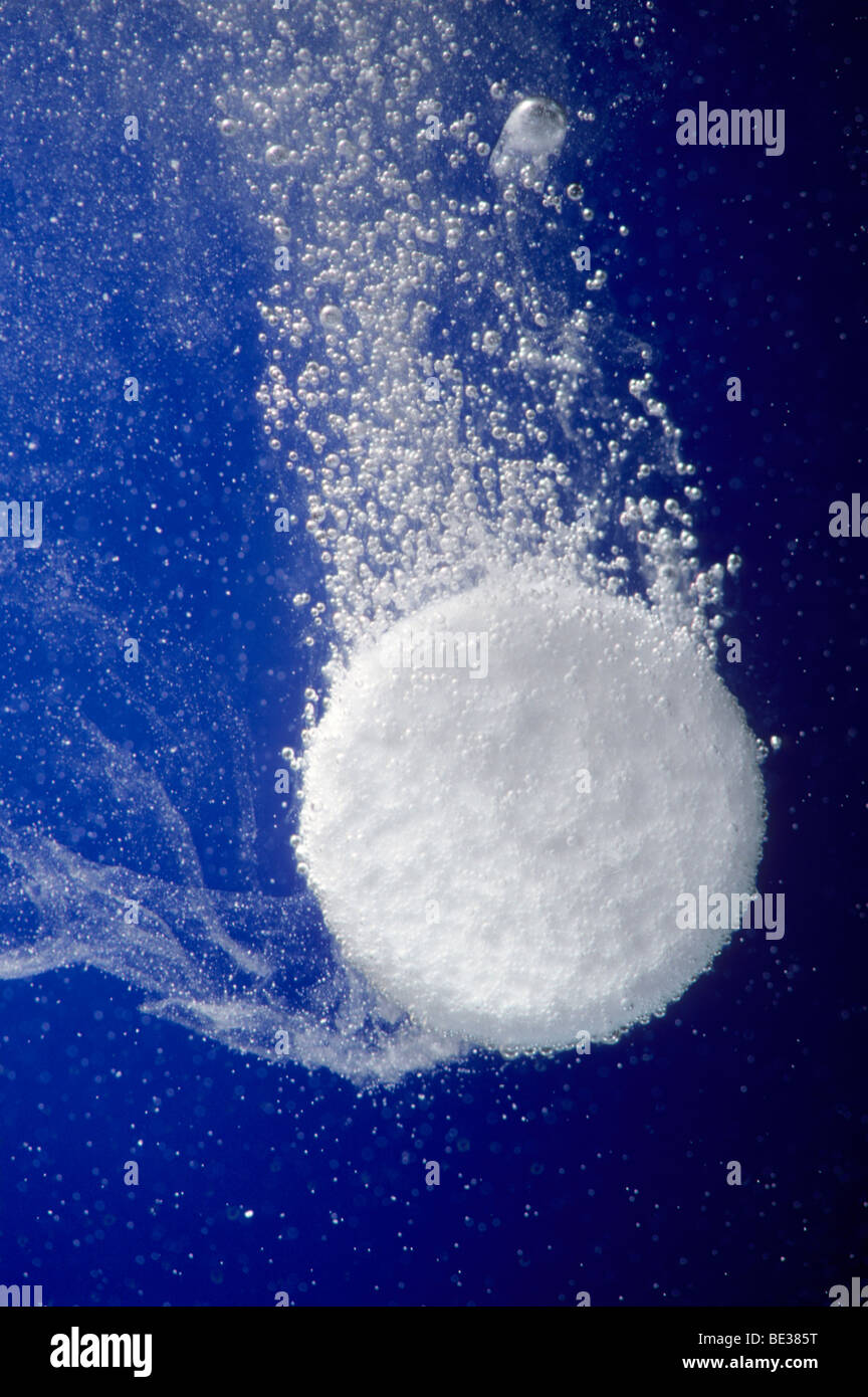 Fizzy, effervescent tablet bubbling in water Stock Photo