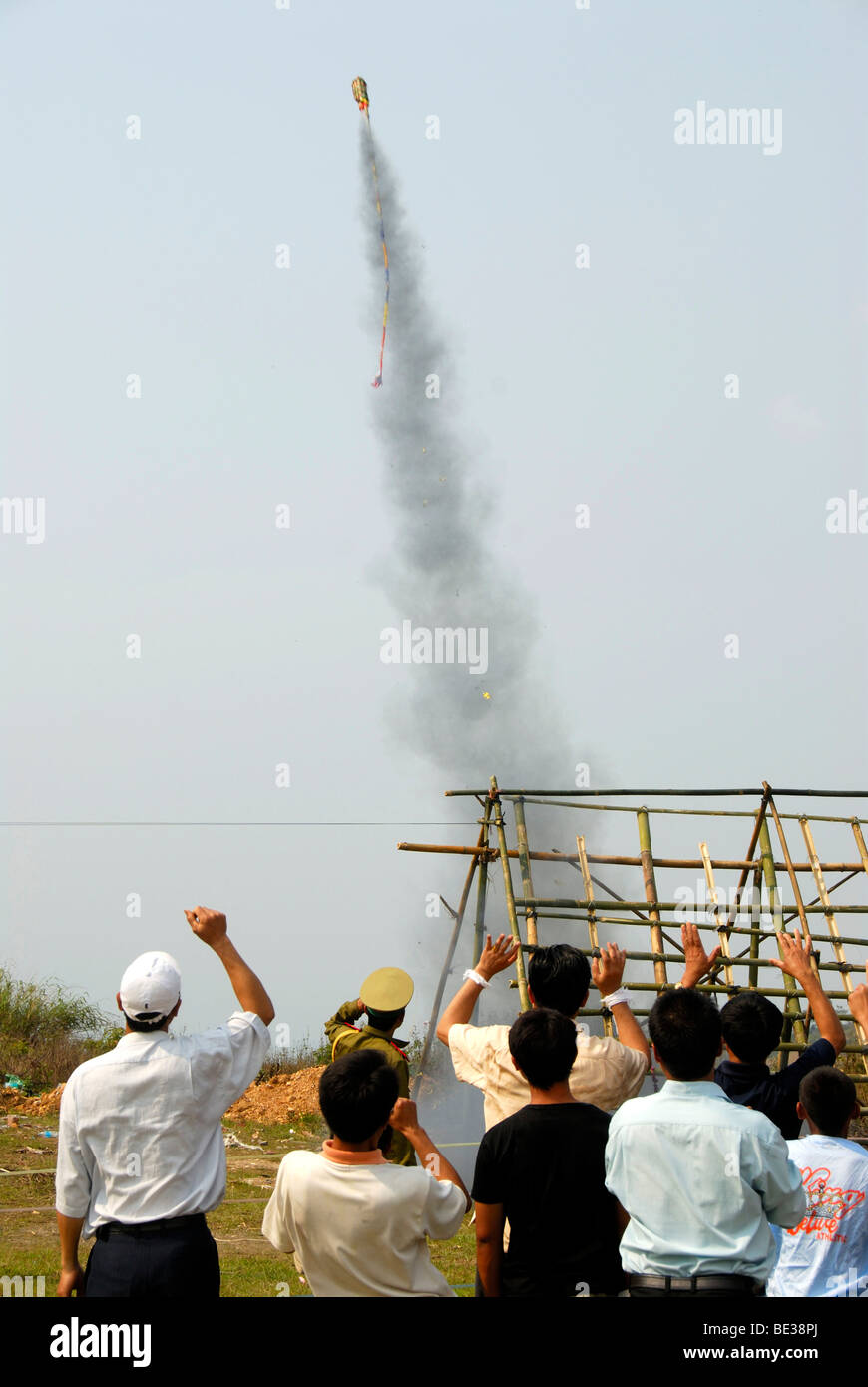 Rocket rising in the sky shortly after launch from a launch pad, cheering spectators, Pi Mai, Lao New Year festival Stock Photo