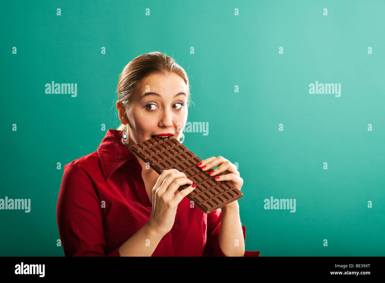 Young woman with enormous bar of chocolate Stock Photo