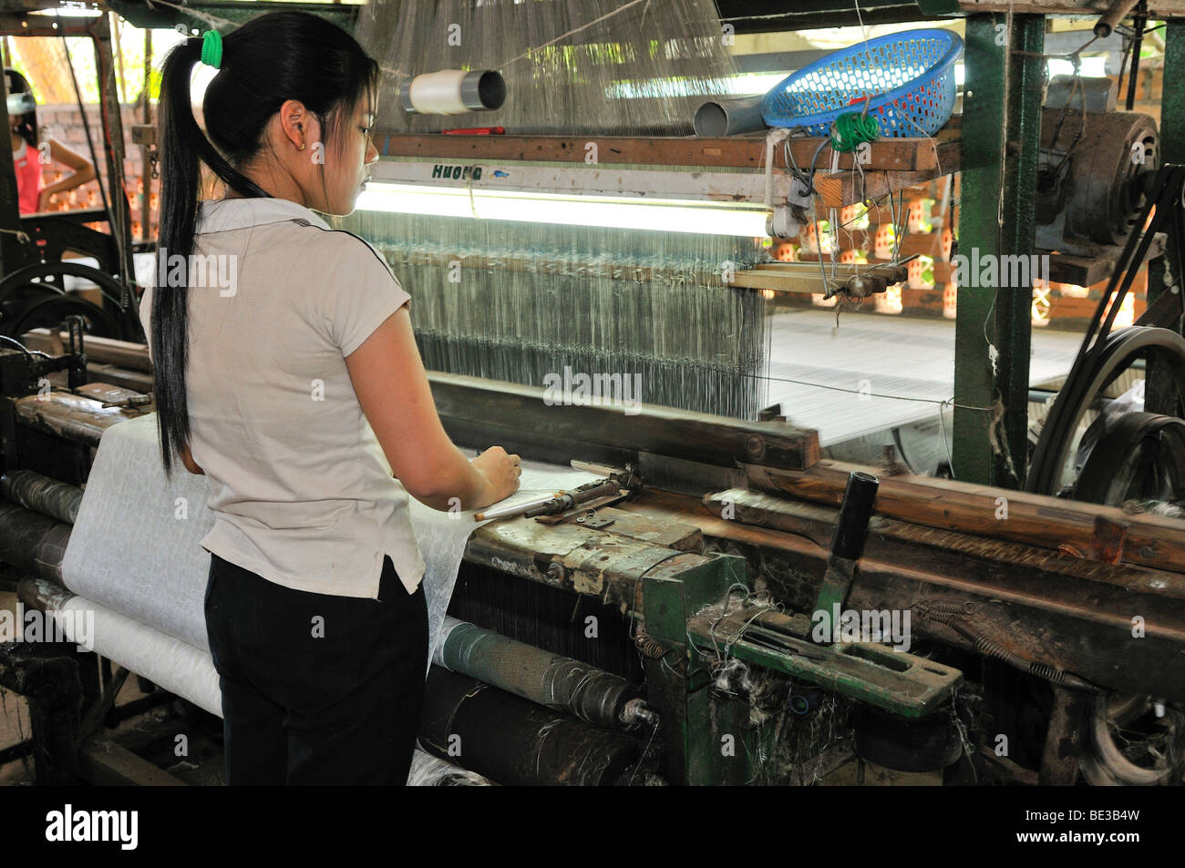 Woman working on a loom in a silk factory, Dalat, Central Highlands, Vietnam, Asia Stock Photo