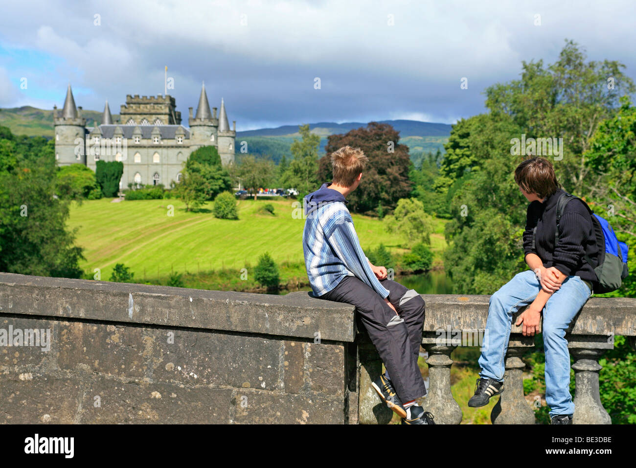 two teenagers sitting on a wall in front of Inveraray Castle, Scotland, Great Britain Stock Photo