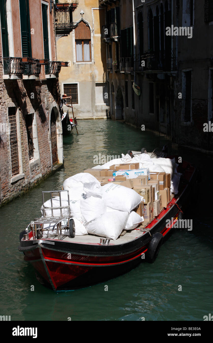 Boat moving  a cargo of supplies along a Venice canal. Stock Photo