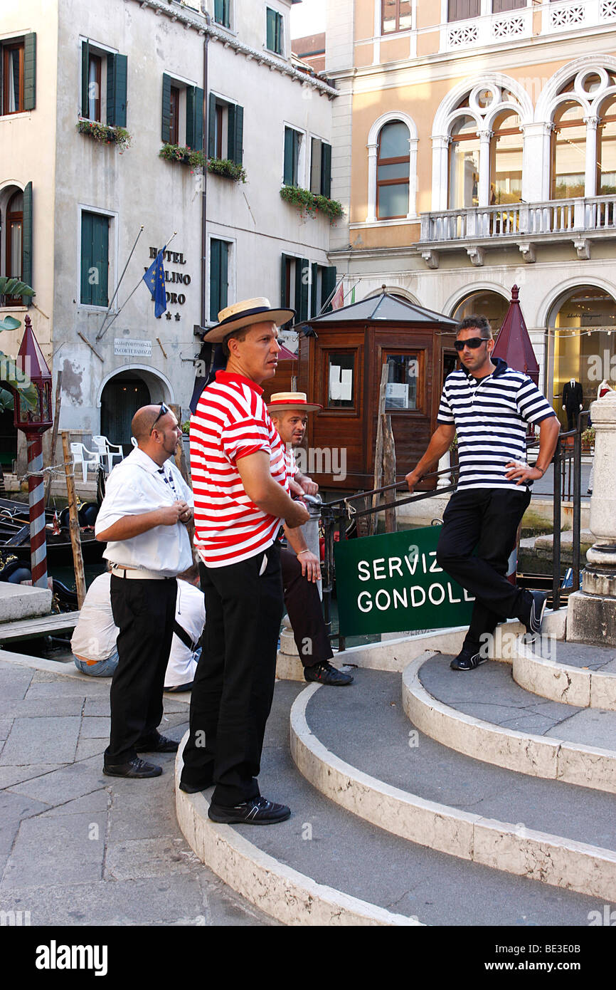 Gondoliers touting for business beside a bridge in Venice,Italy Stock Photo
