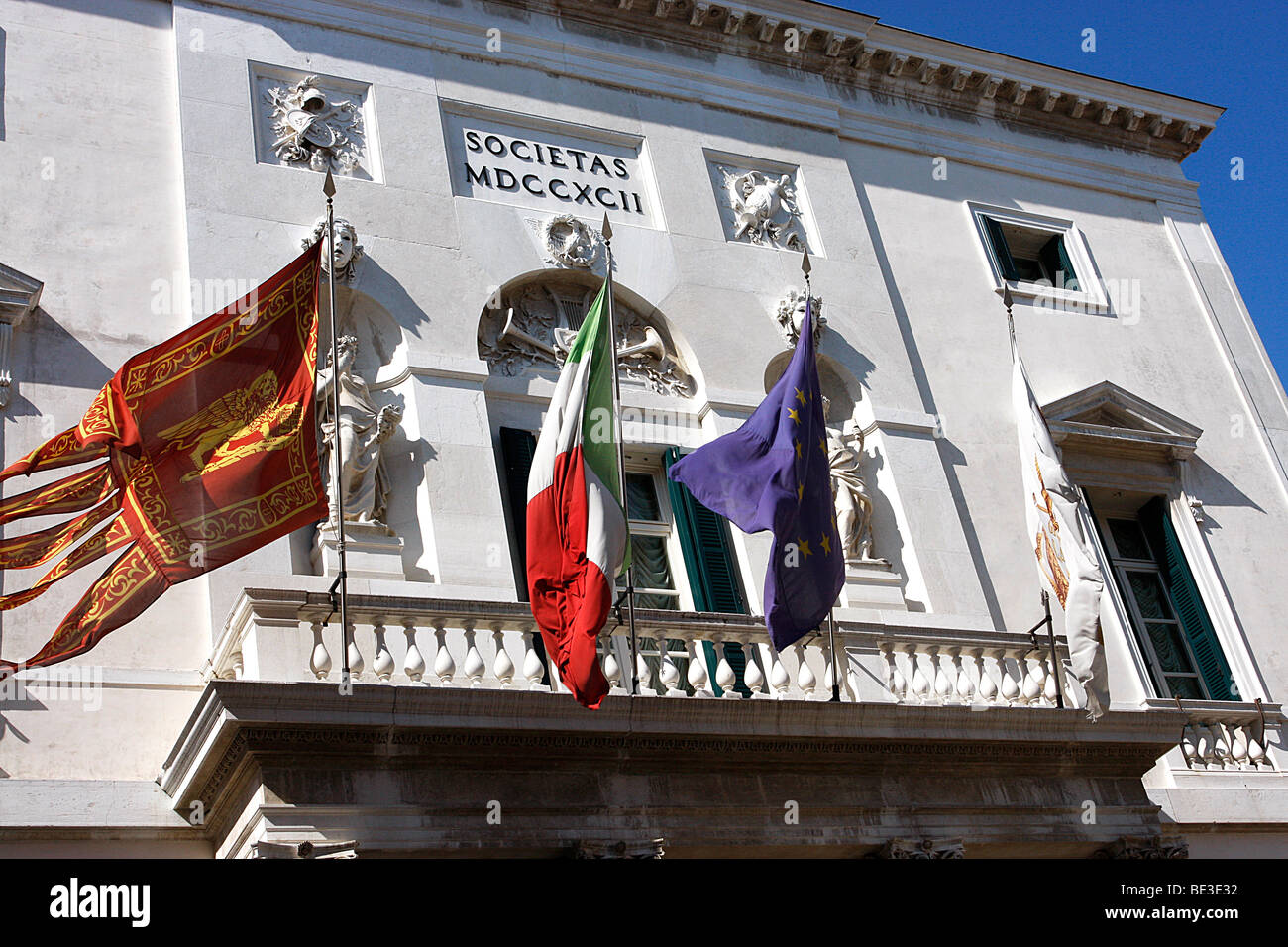 Flags flying on the fascia of the famous 'La Fenice' theater  Venice,Italy Stock Photo