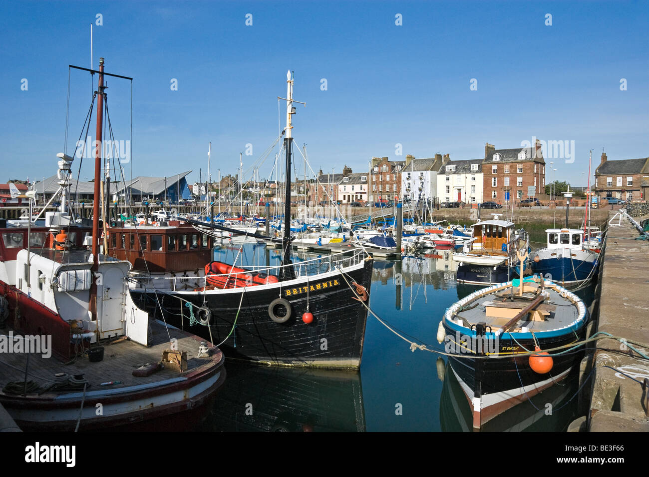 Arbroath Harbour in Scotland with vessels moored and Shore Street in the background Stock Photo