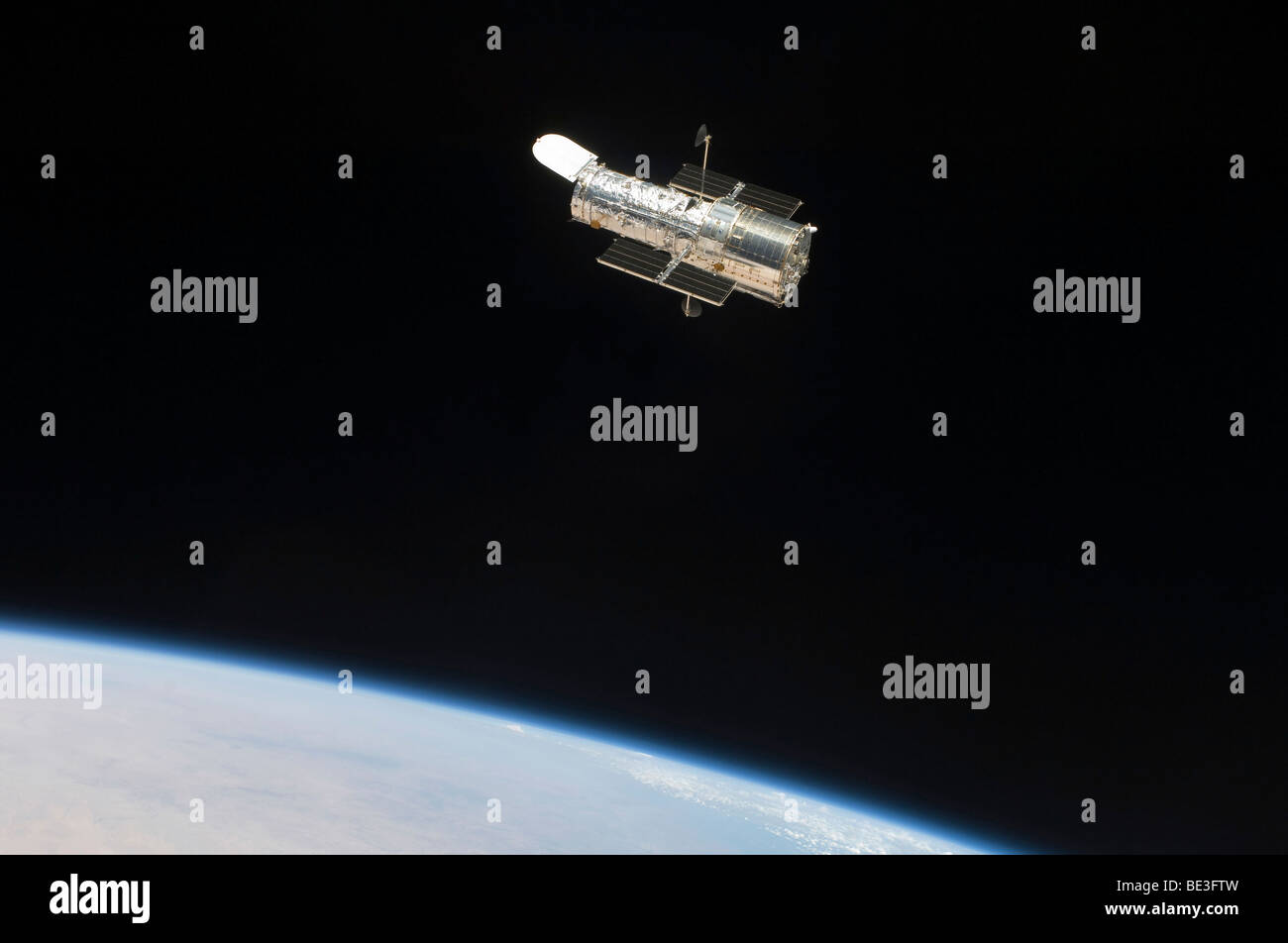The Hubble Space Telescope in orbit above Earth. Stock Photo