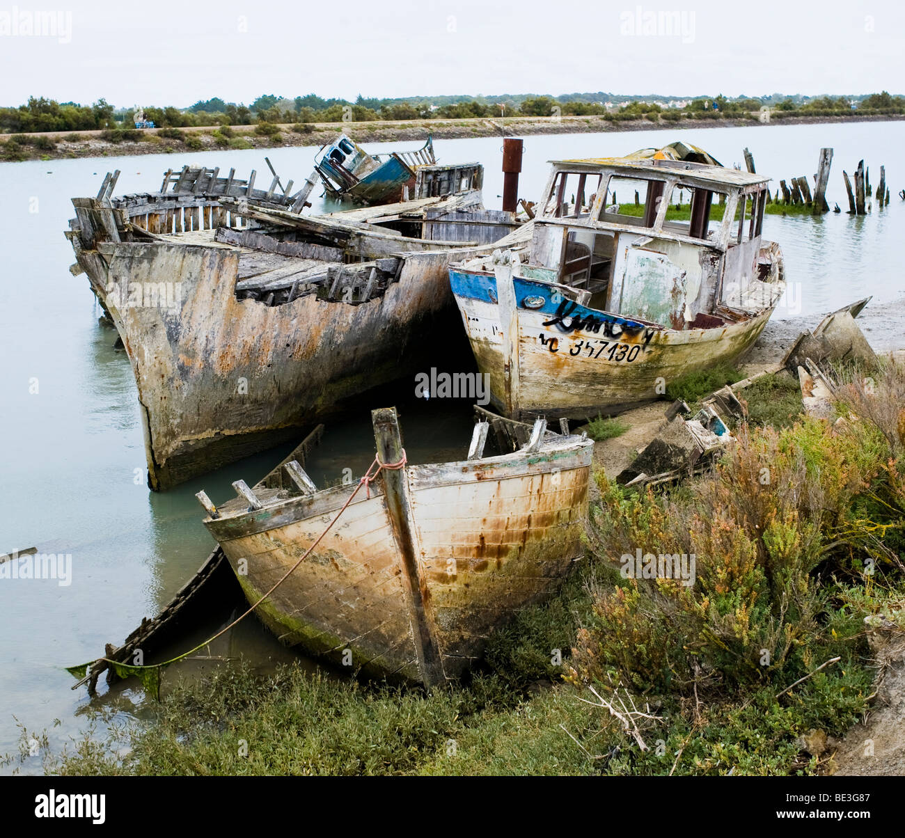 Sunken boats lay in a river feeding the bay of Biscay on the Island Lle