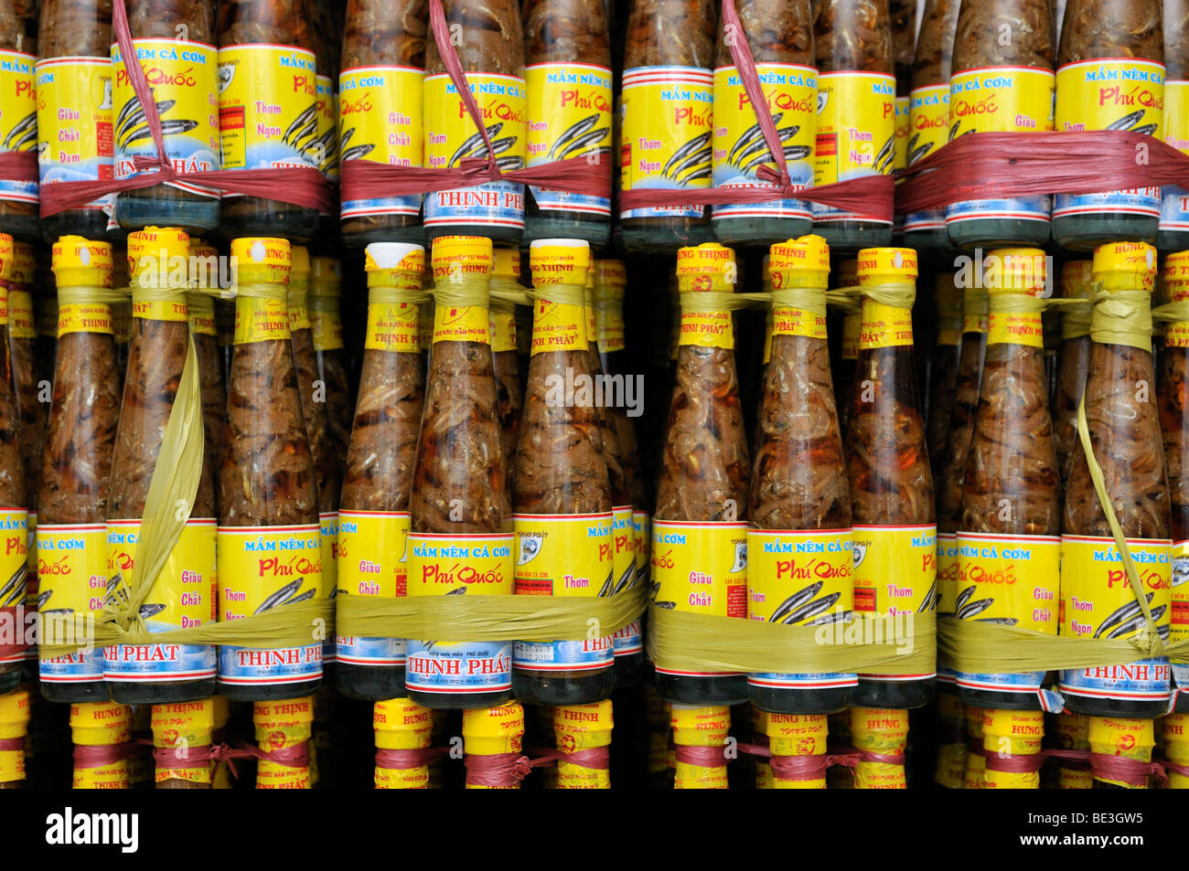 Shelf with the traditional Vietnamese fish sauce Nuoc Mam in glass bottles with yellow plastic cap, Phu Quoc, Vietnam, Asia Stock Photo