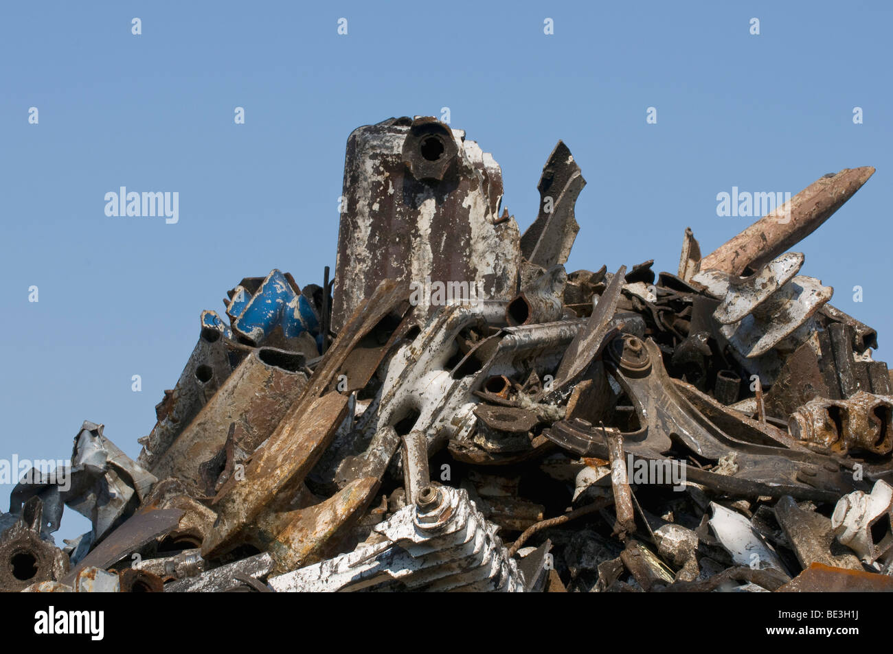 Scrap, waste, scrap metal piled up against a blue sky Stock Photo