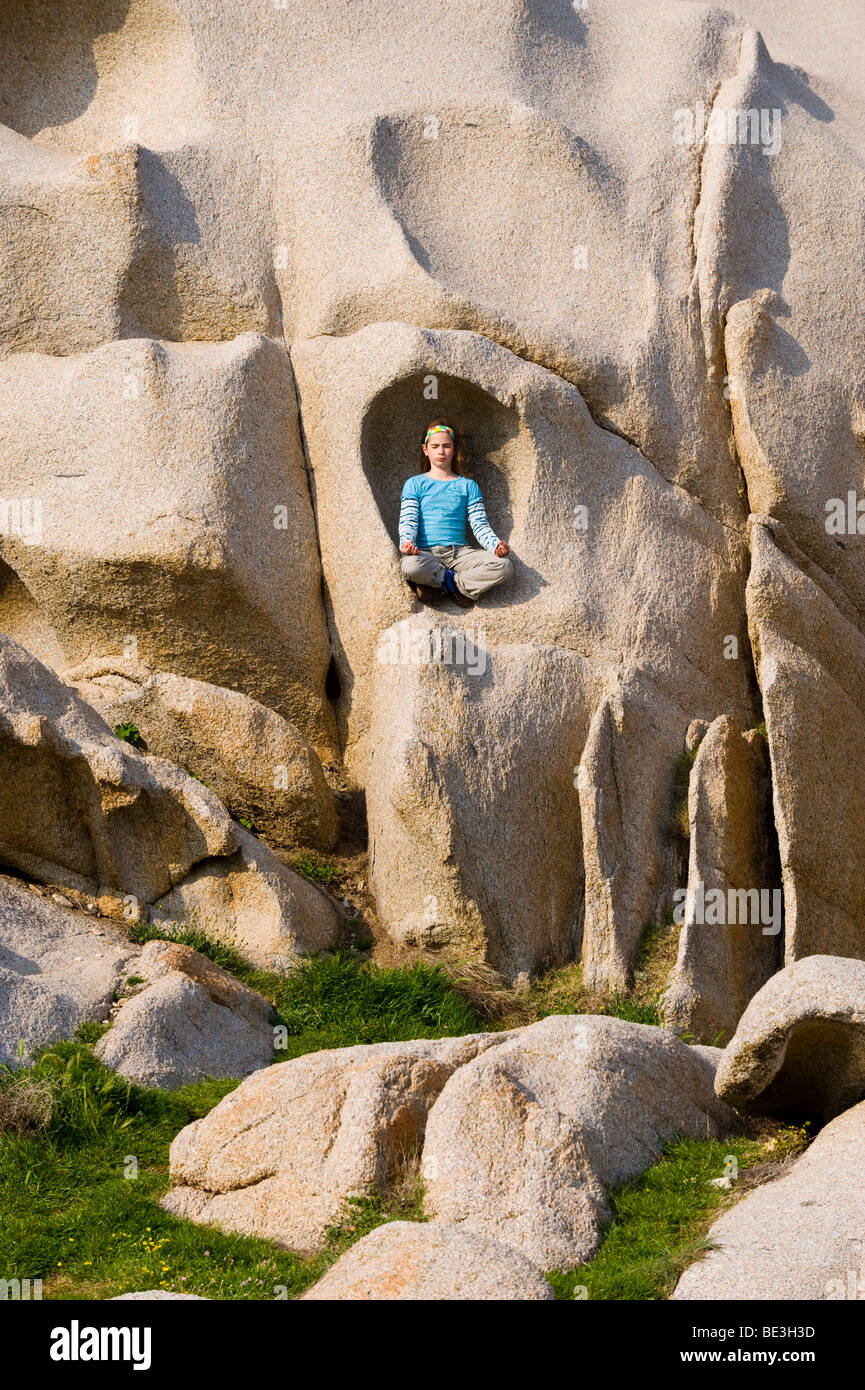 Girl meditating in a rock, Capo Testa, Sardinia, Italy, Europe Stock Photo