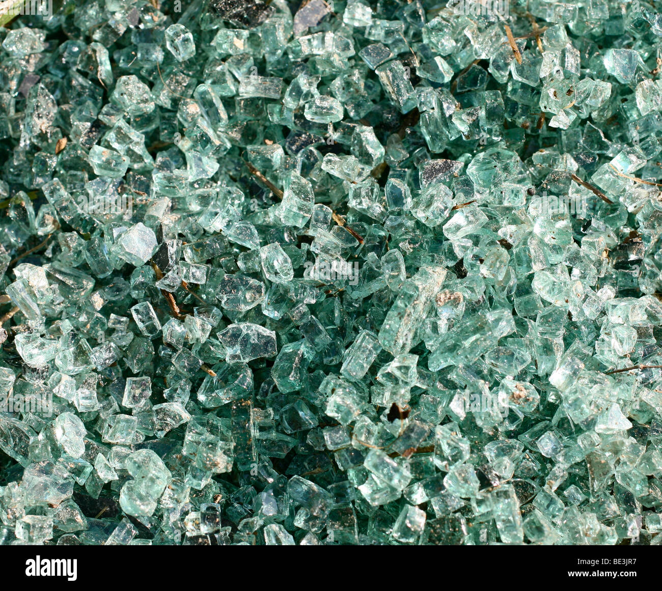 Broken blue-green windscreen glass lying at the roadside Stock Photo