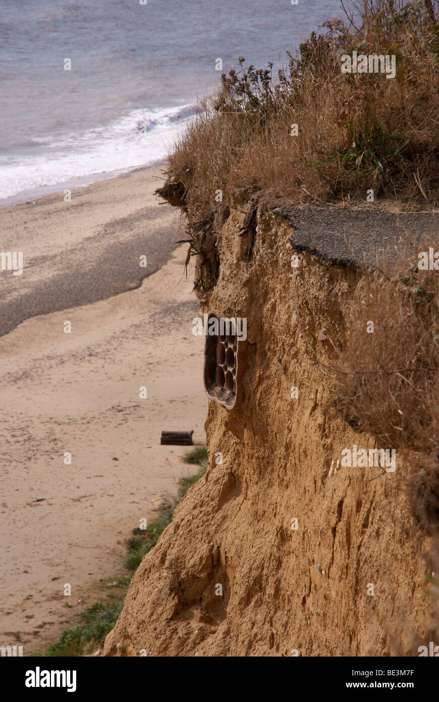 Coastal cliff erosion showing severed drains and roadway Stock Photo