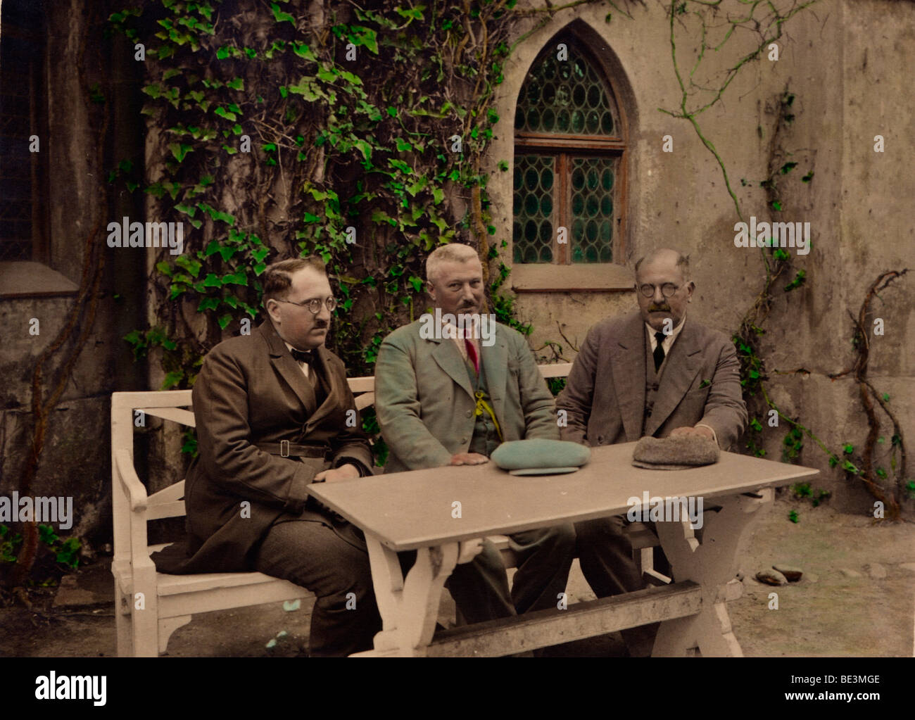 Men in suits sitting on a bench, hand colorised photo, historic photo from 1929 Stock Photo