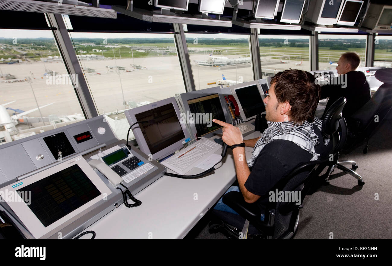 Two air-traffic controllers in 78 m high main tower of Munich Airport looking on to the apron West and Terminal 1, Bavaria, Ger Stock Photo