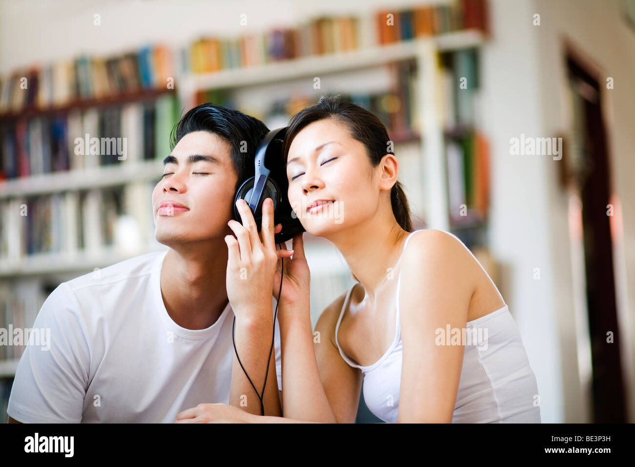 Asian couple listening to music together with headphones Stock Photo