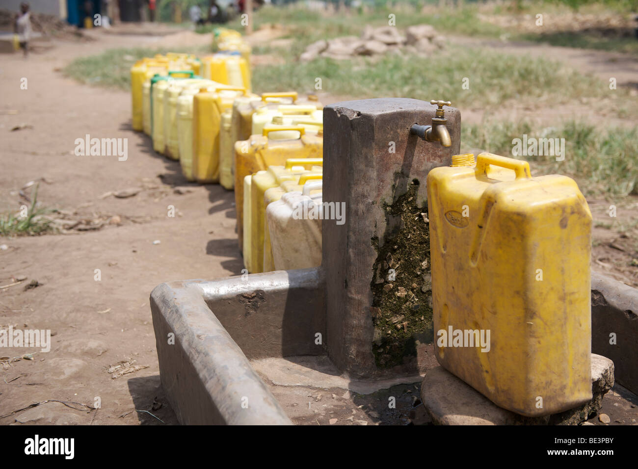 Plastic containers waiting to be filled at a tap in western Uganda Stock Photo Alamy