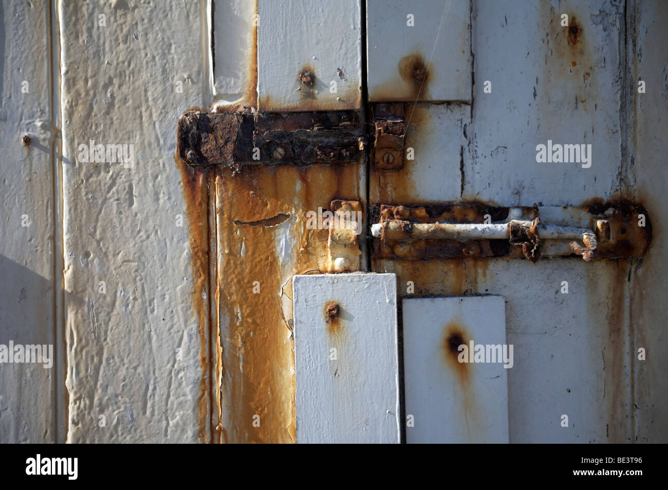 Rusty bolts on a peeling white painted door Stock Photo Alamy