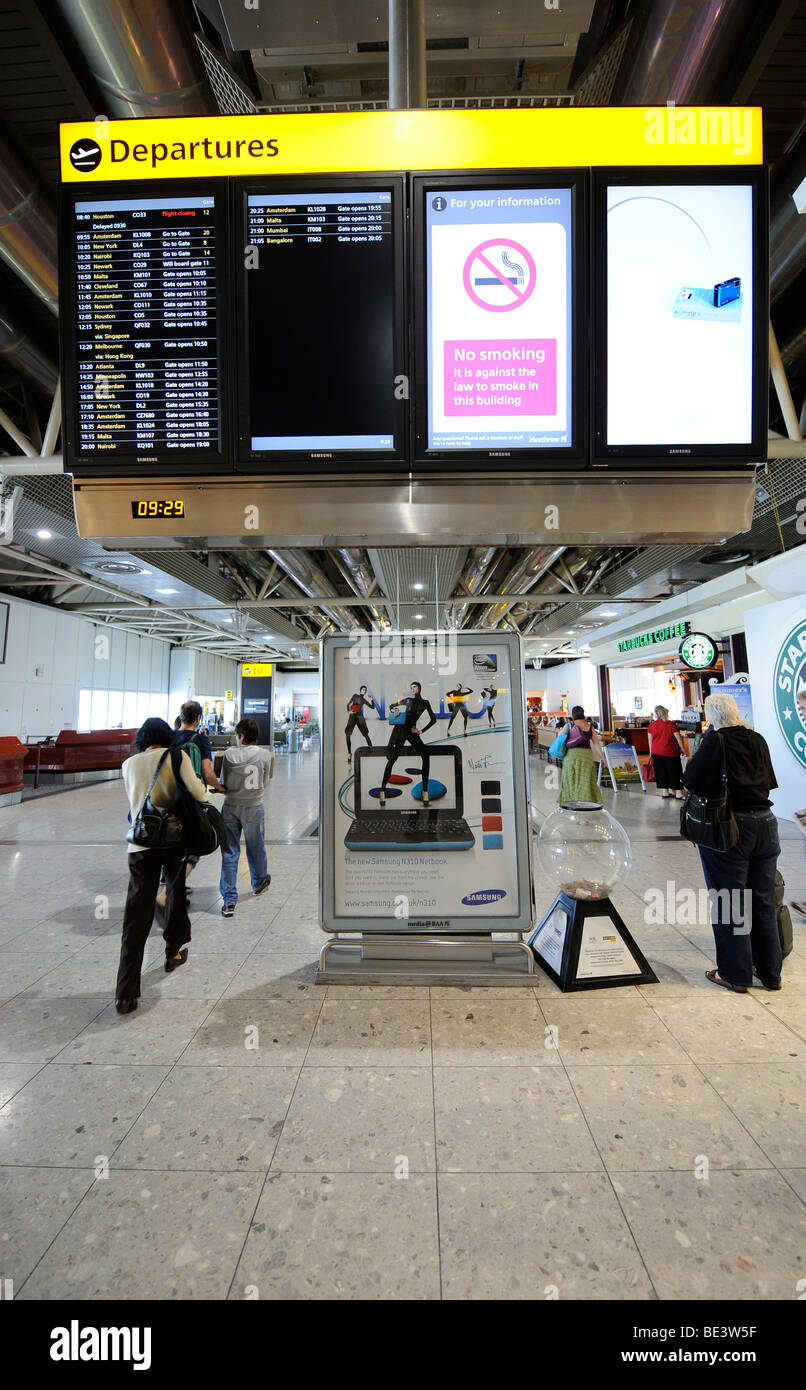 Display board and passengers at an airport gate, waiting area, BAA Heathrow International Airport, Terminal 4, London, England, Stock Photo