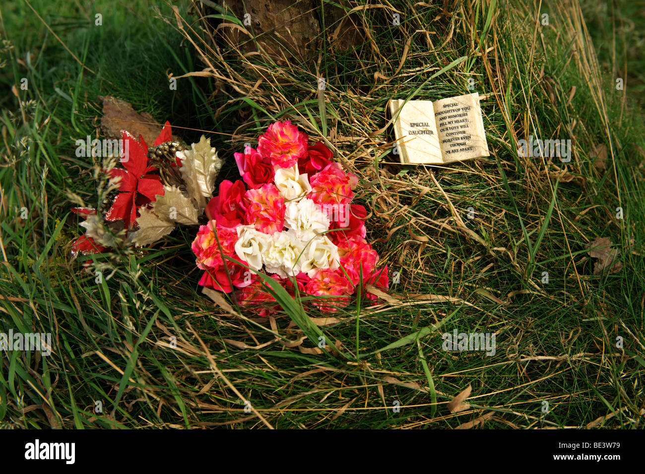 Arrangement of flowers on the ground left as a floral tribute to a dead daughter, UK Stock Photo