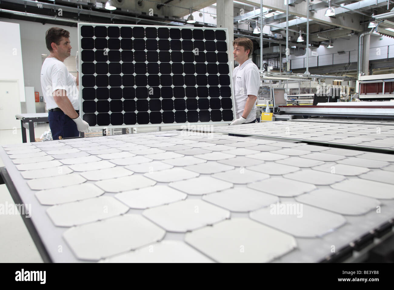 Solon SE: production of solar panels. Workers carrying a a finished panel, BERLIN, GERMANY Stock Photo