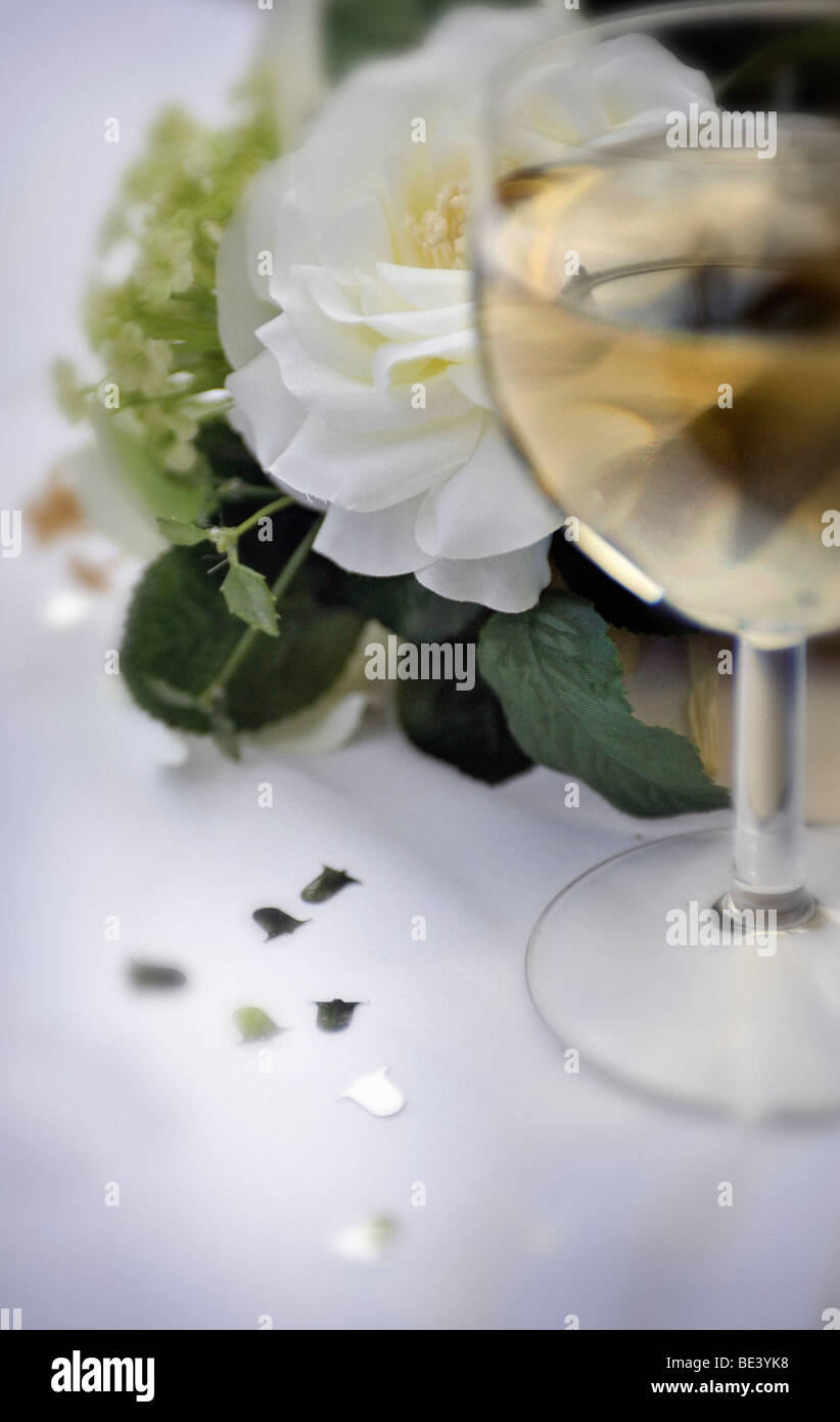 Wine Glass With White Wine Confetti And Artificial Flowers On