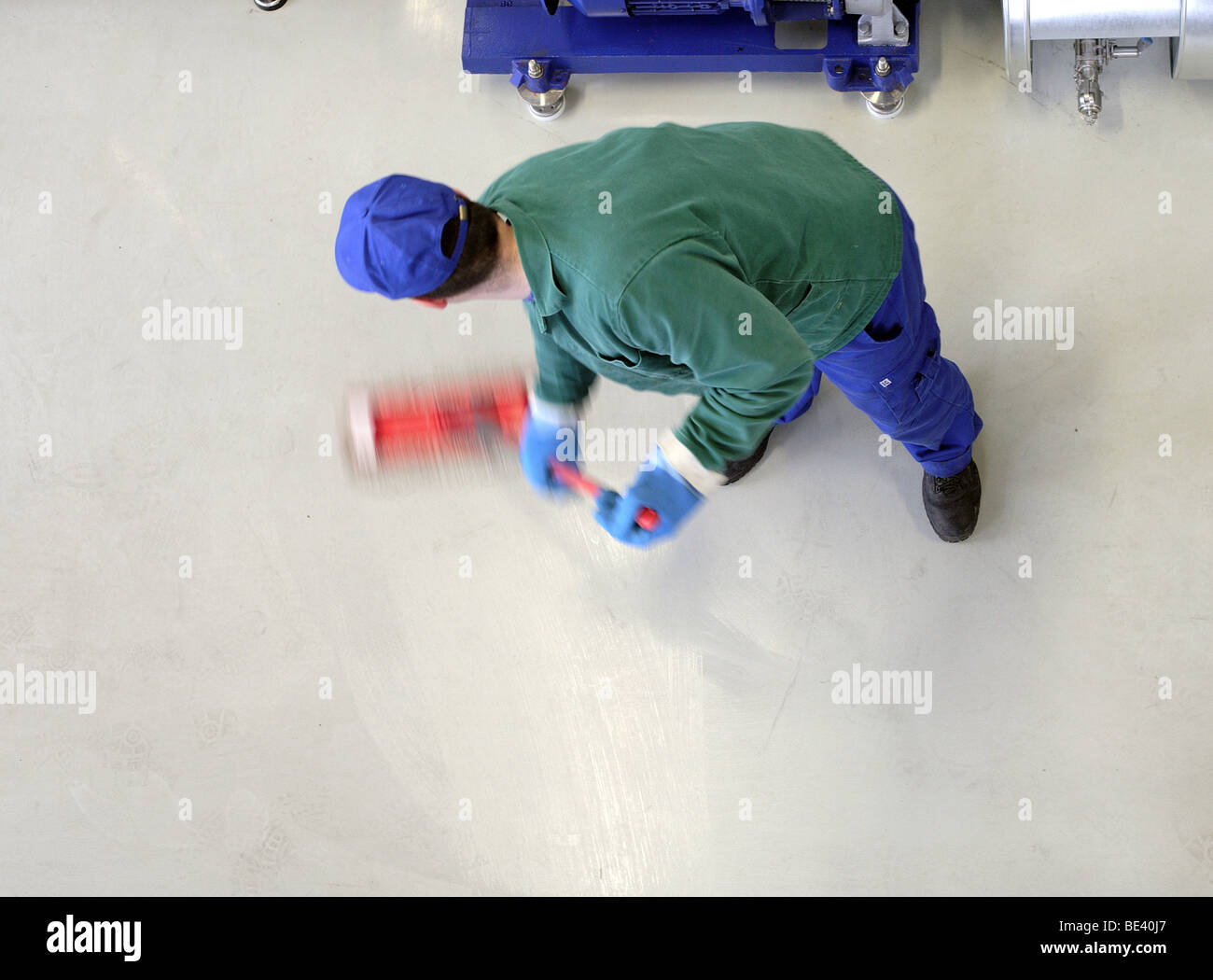 MAN AT WORK. CLEANING THE FLOOR. Stock Photo