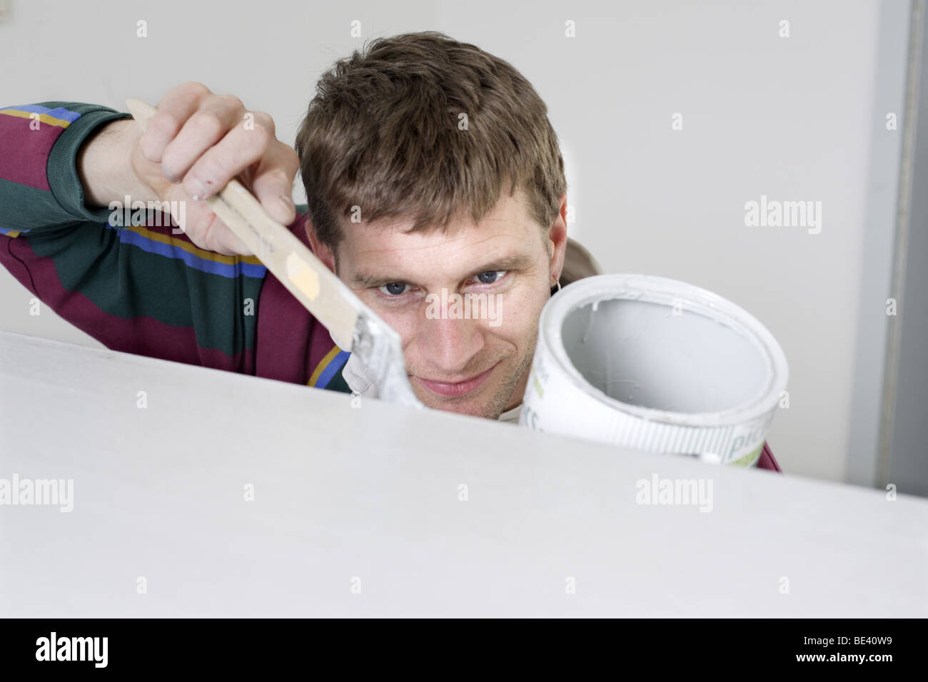 Junger Mann bei Malerarbeiten Stock Photo