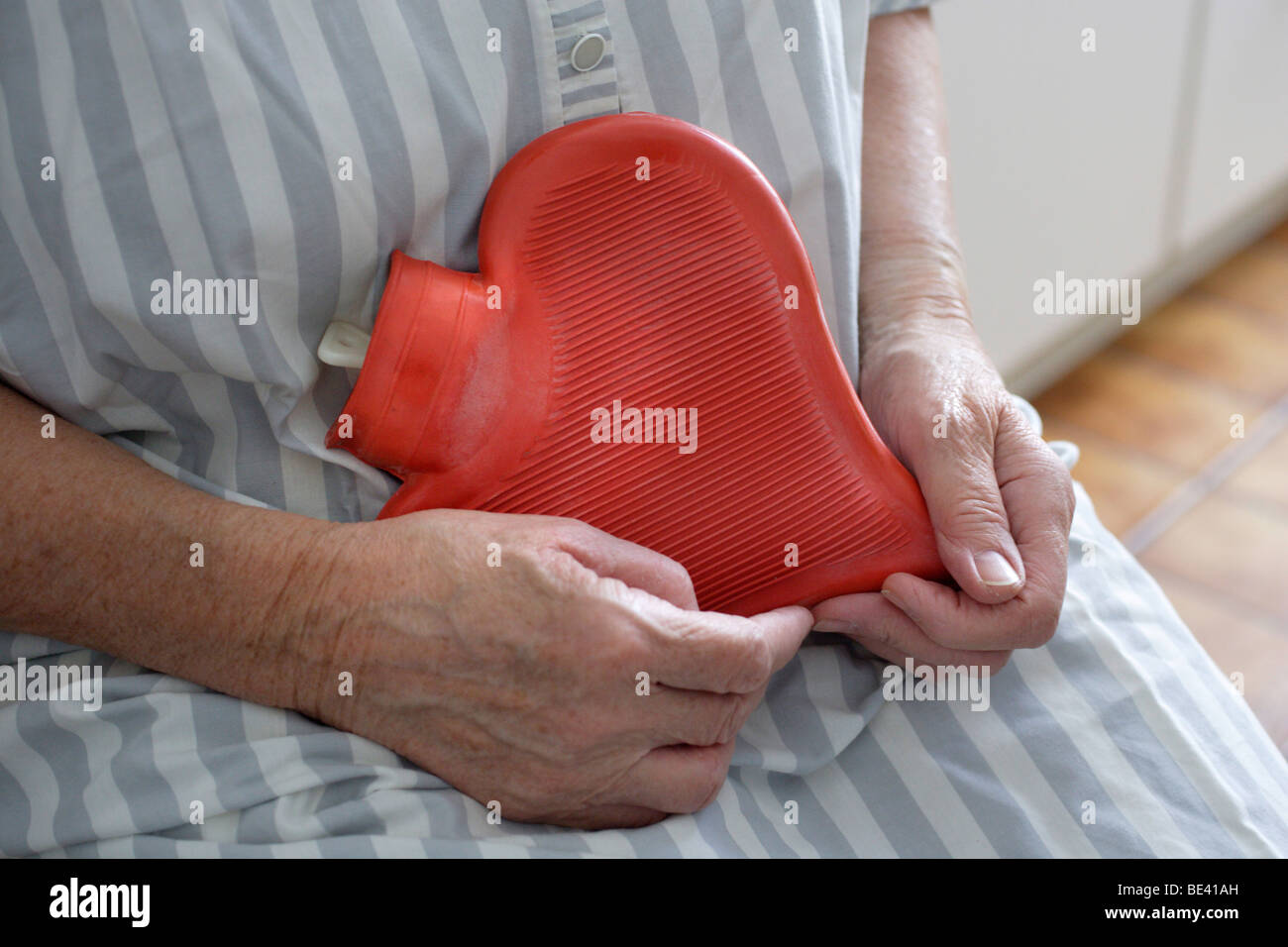 Pflegefall , Gesundheitssystem . Seniorin mit einer Herzwaermflasche . Stock Photo