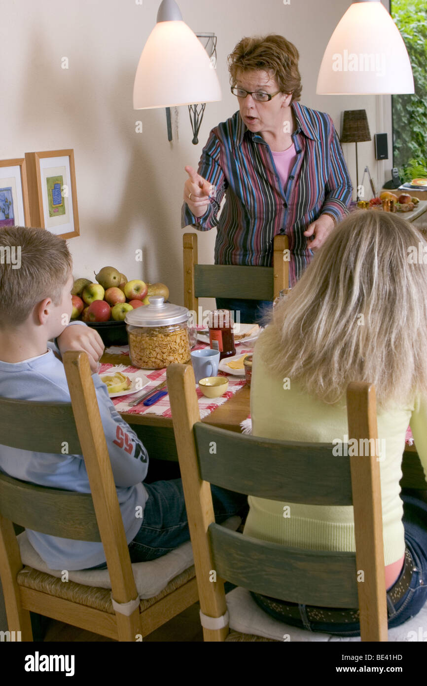 Verbal abuse: Demanding mother telling off her children at home at dining table and being an aggressive mom. SerieCVS417009 Stock Photo