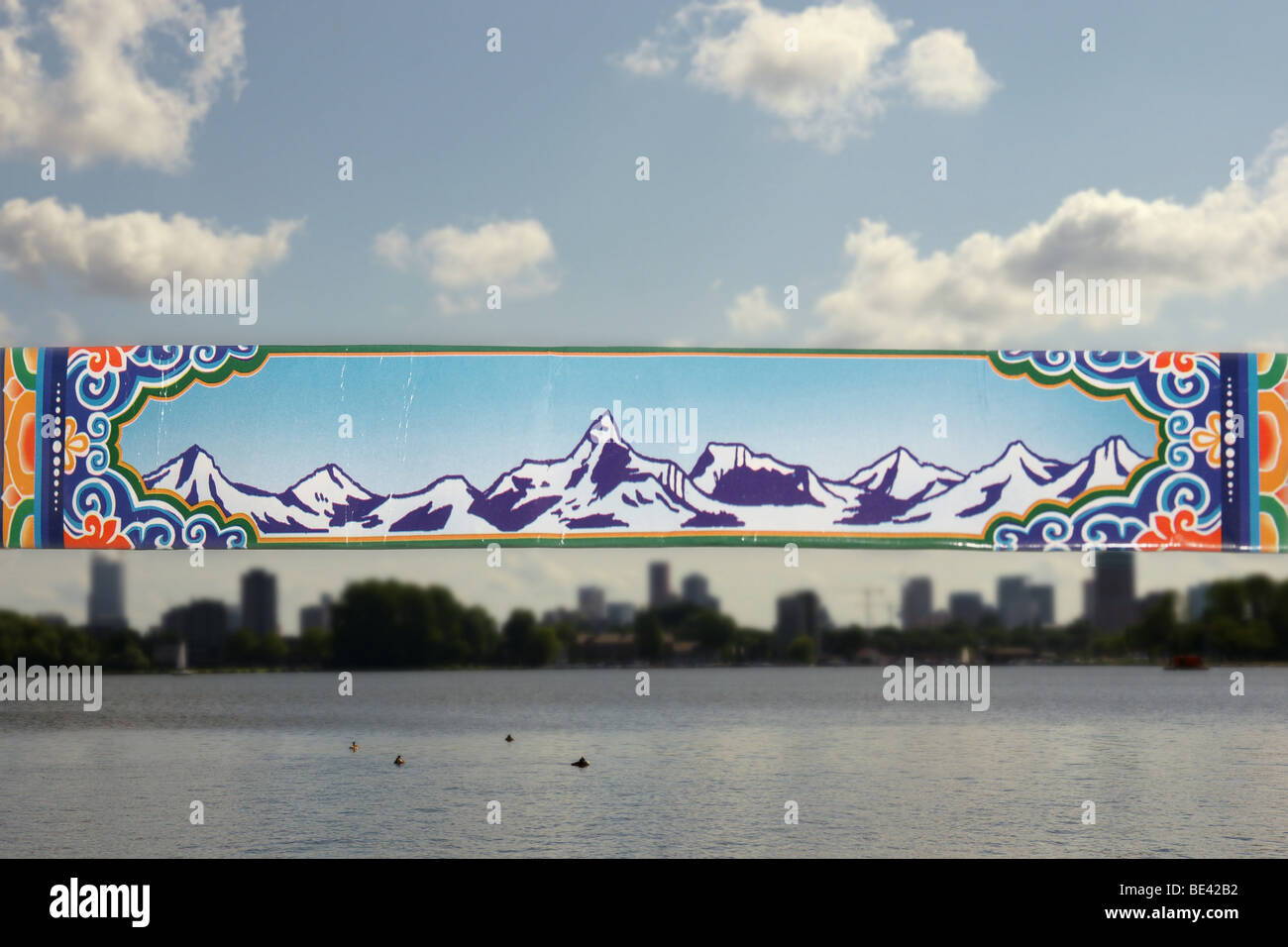 A silhouette of Himalayas on a paper tape aligned to a cityscape of Rotterdam, Netherlands above Kralingen lake Stock Photo