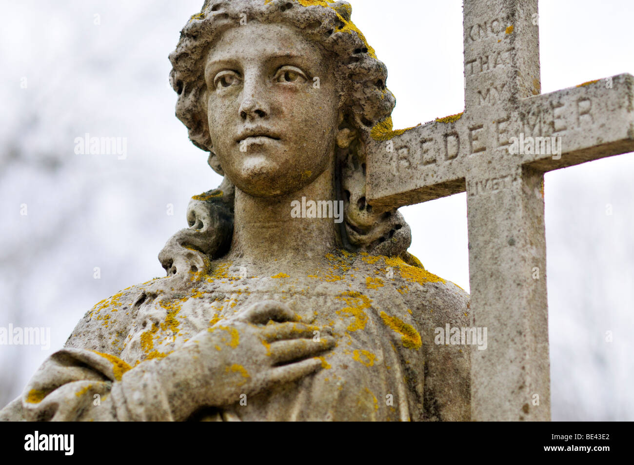Cemetery statue of woman holding Cross of the Redeemer Stock Photo