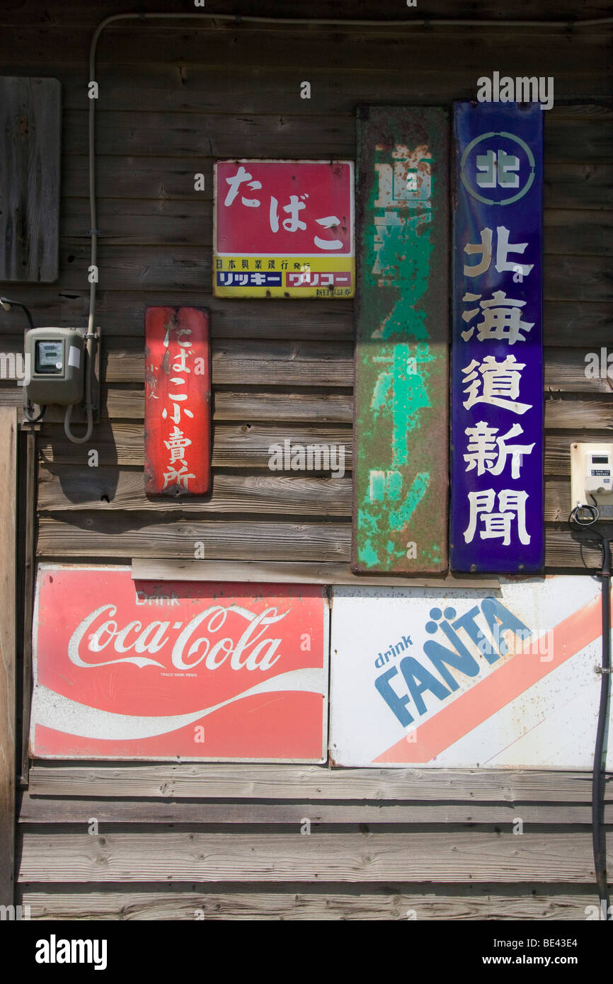 Old soft drink, cigarette and newspaper signs rusted and faded by the ...