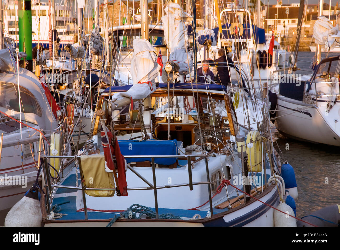 Yarmouth leisure yacht harbour IOW full crowded packed rigging boom mast dust orange glow relaxed Stock Photo