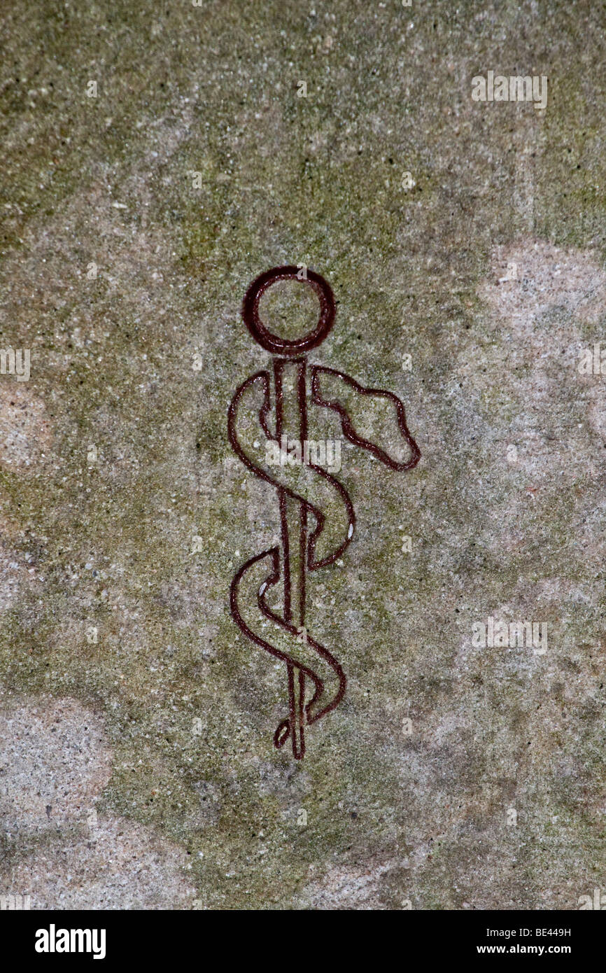 Aesculapian staff, rod of Asclepius carved into a wall, symbol of the
