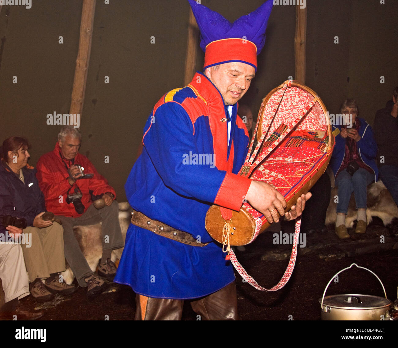 Sami man in traditional clothing shows a cradle used for infants and talks about daily life Stock Photo