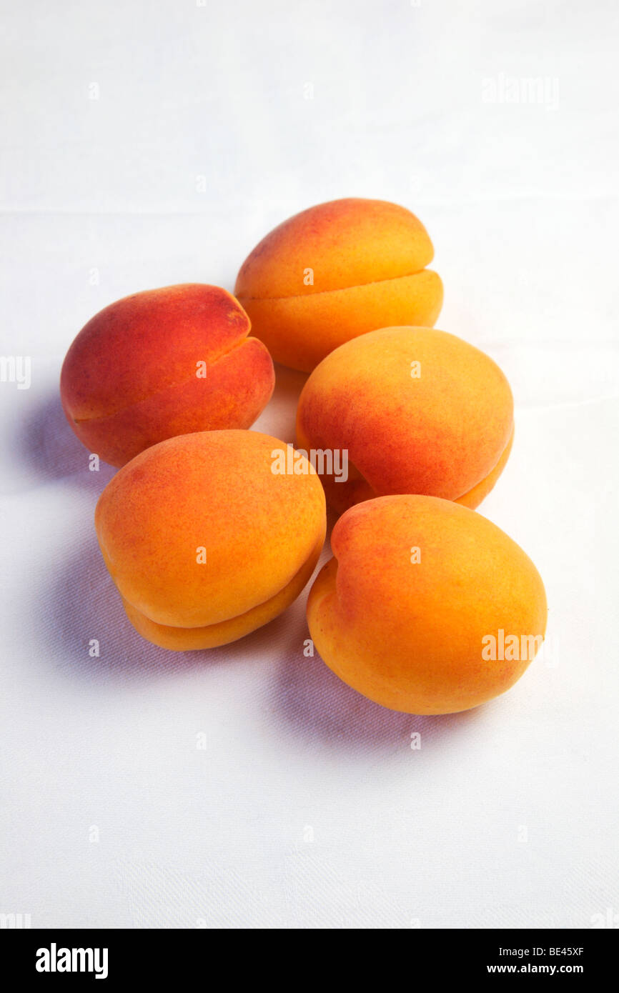 Five apricots on a white cloth Stock Photo
