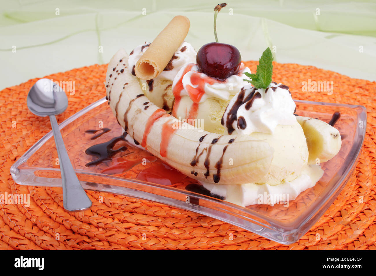 Banana split with vanilla ice cream, chocolate and strawberry sauce, whipped cream with cherries and mint leaf Stock Photo
