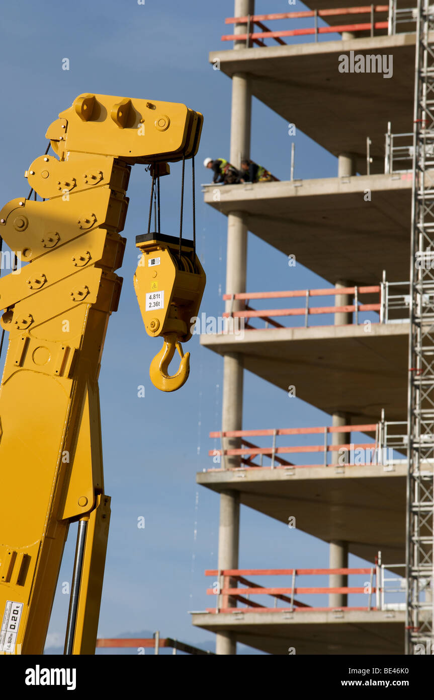 Construction workers fitting safety rails to s partly built office ...