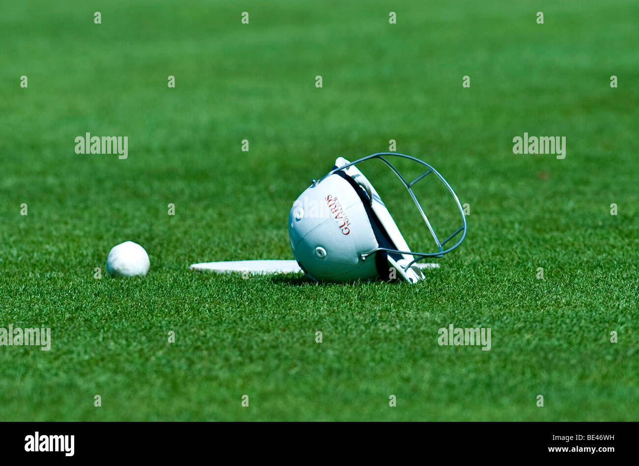 A polo helmet and ball on the lawn Stock Photo