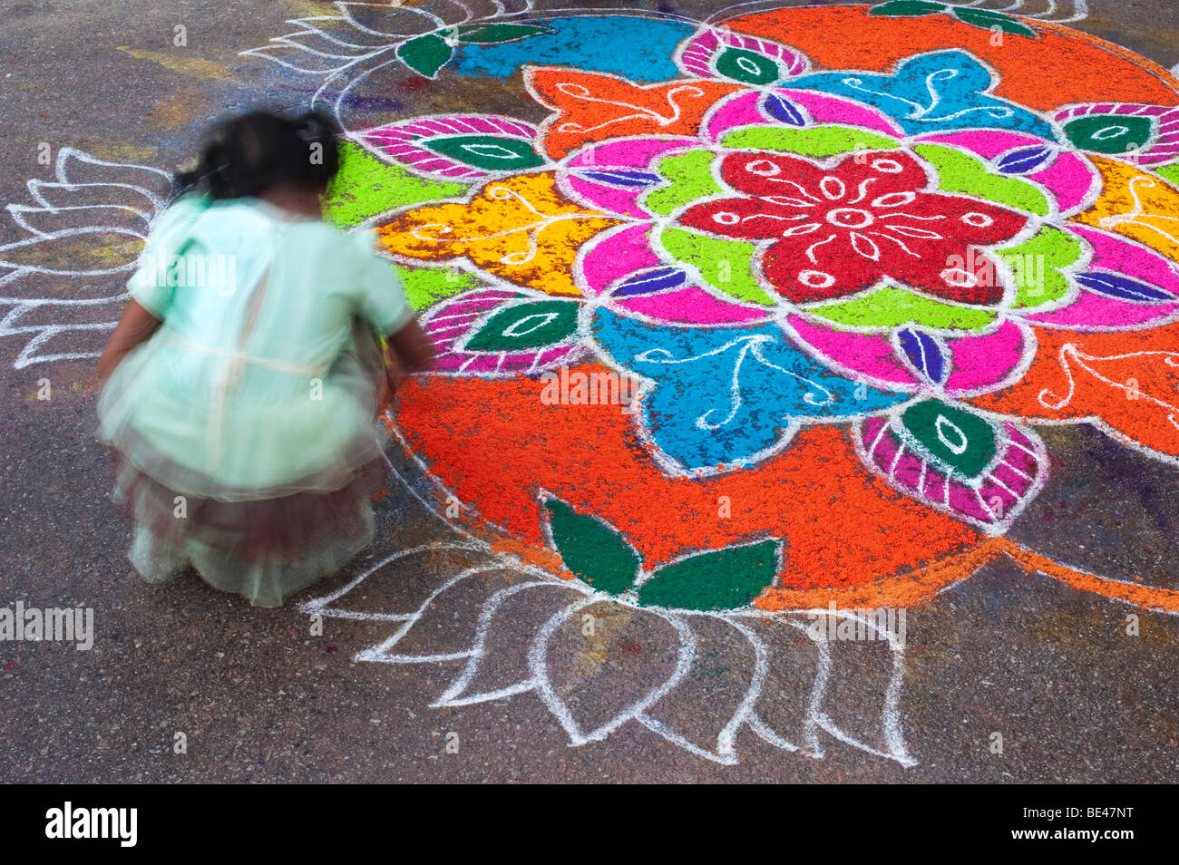 Indian women making a Rangoli festival design in an Indian street ...